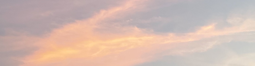 evening sky with clouds reflecting pink, yellow and blue